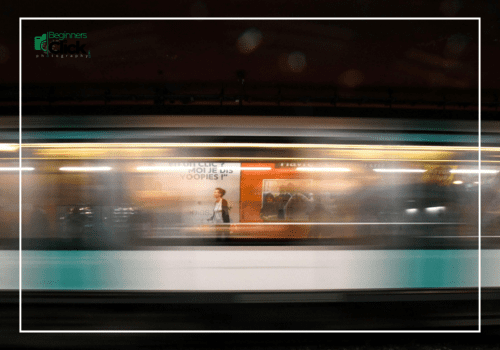 Motion blur of a moving metro train with sharp background posters in focus.