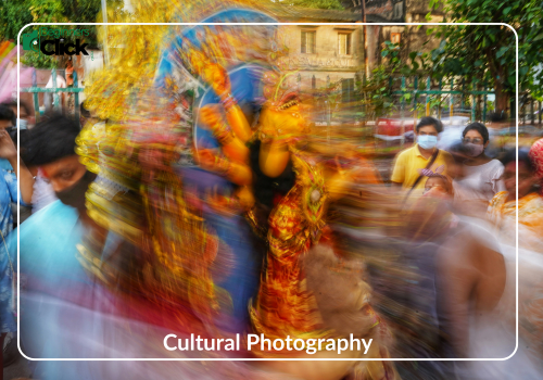 Movement & Tradition – Cultural Photography Blurred image of a colorful cultural event with people in motion and traditional costumes; labeled “Cultural Photography” with “ISO (12)” and the Beginners Click Photography logo.