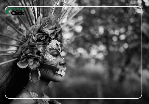 Expression in Monochrome – Black & White Photography A woman wearing elaborate ethnic and floral headgear, face paint, and earrings, captured in profile against a blurred outdoor background in black and white.