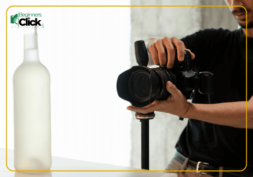 Product Photography in Action A person photographing a frosted bottle using a DSLR camera mounted on a monopod, with the logo "Beginners Click Photography" in the top-left corner.