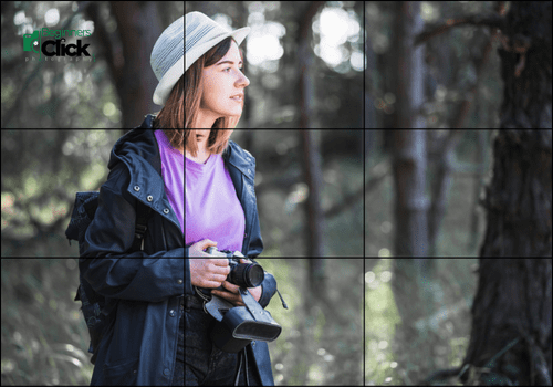 In Search of the Perfect Shot: A Photographer in Nature A young woman photographer in a white hat and purple shirt holding a camera in a sunlit forest, using the rule of thirds composition.