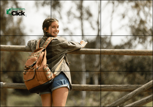 Rule of Thirds: Creating Dynamic Balance in Outdoor Portraits A smiling young woman with a backpack stands at a wooden fence, positioned on the left third of the frame, looking back over her shoulder.