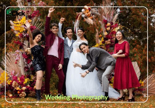 Joyful Wedding Photography Moment A joyful group of people, including a bride in a white gown, posing playfully under a floral arch; text reads “Wedding Photography” with the Beginners Click Photography logo at the top left.