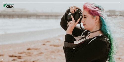 Colorful Hair Photographer Shooting by the Sea Female photographer with colorful hair taking photos on a beach.