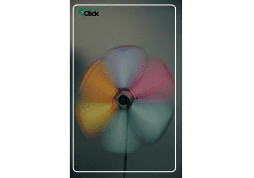 Motion Blur of a Colorful Spinning Fan Colorful spinning fan captured with motion blur against a plain background.