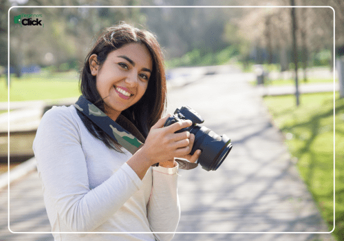 Photography Enthusiast Ready to Capture Moments Learning photography from scratch – A young woman smiling while holding a DSLR camera in a park.