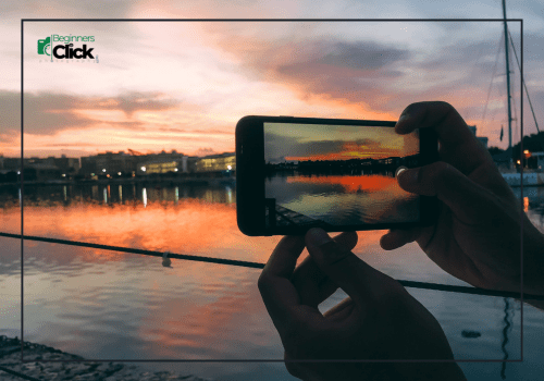 Lighting is everything A smartphone capturing a sunset reflection on the water with vibrant orange and pink sky.